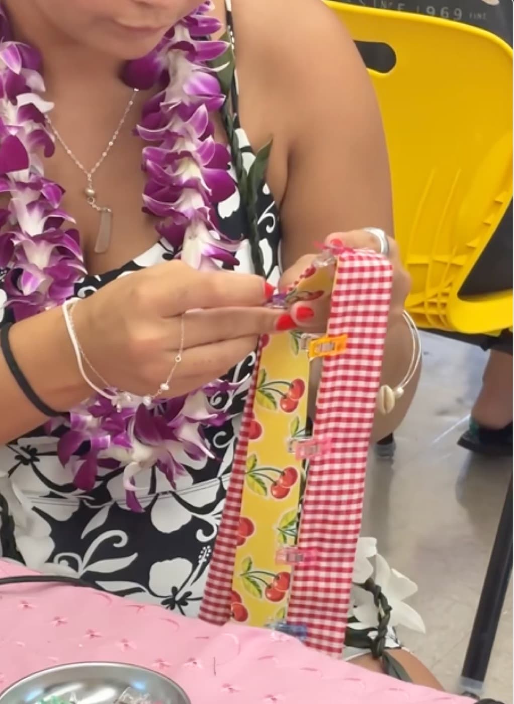 Close-up of hands clipping gingham and cherry-print fabric together